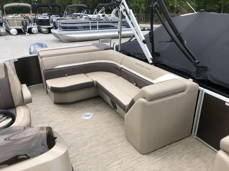 Slide: The Image of 2023 Bennington 21 SXL pontoon boat with beige seating and spacious deck area. - 4