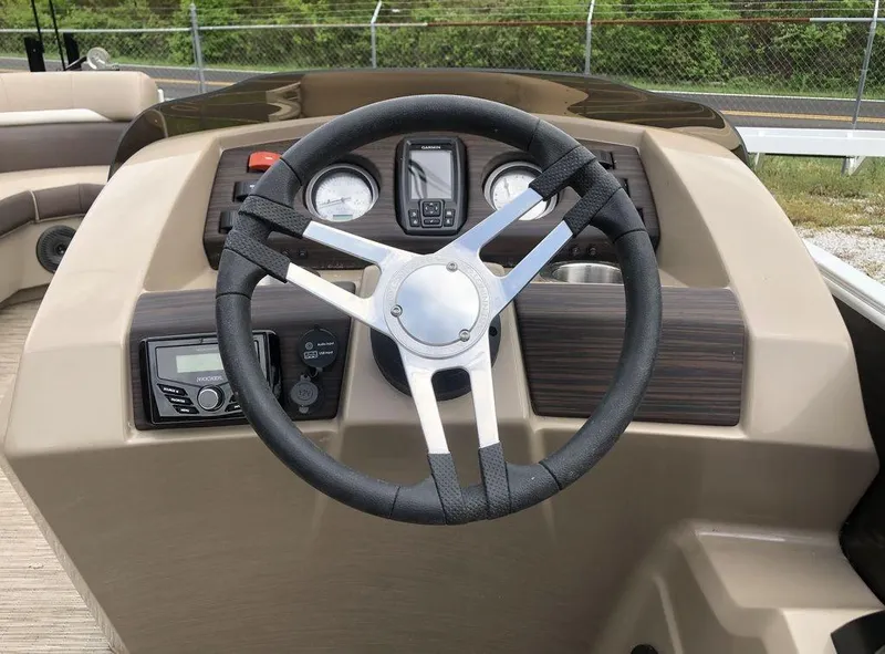 Slide: The Image of Steering wheel and dashboard of 2023 Bennington 21 SXL boat, featuring modern controls and gauges. - 5