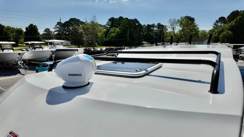 Slide: The Image of 2025 Bayliner Trophy 23 Pilothouse roof with radar and hatch, parked outdoors. - 12