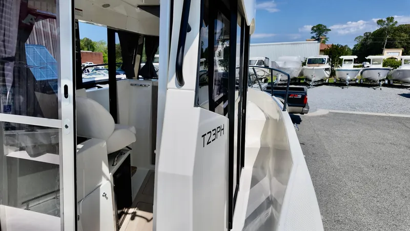 Slide: The Image of 2025 Bayliner Trophy 23 Pilothouse boat exterior at a marina, showcasing sleek design. - 14