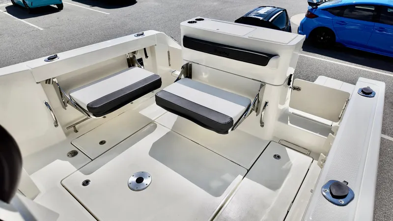 Slide: The Image of 2025 Bayliner Trophy 23 Pilothouse boat interior with foldable seating in a parking lot. - 19