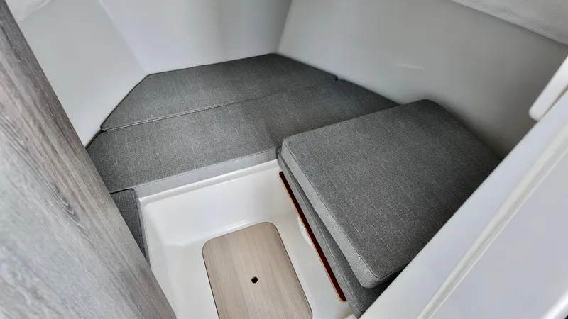 Slide: The Image of 2025 Bayliner Trophy 23 Pilothouse interior cabin with cushioned seating and storage. - 21