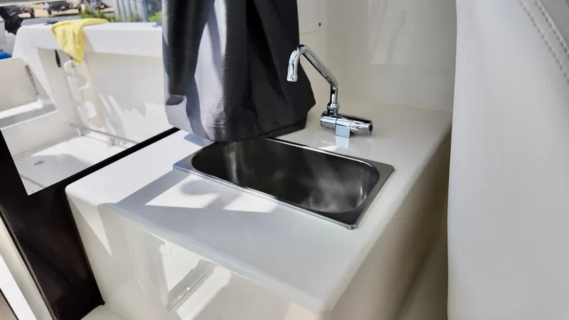 Slide: The Image of 2025 Bayliner Trophy 23 Pilothouse interior sink with chrome faucet. - 24