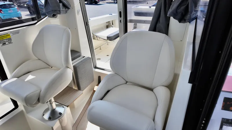 Slide: The Image of 2025 Bayliner Trophy 23 Pilothouse interior with plush white seating and modern design. - 27