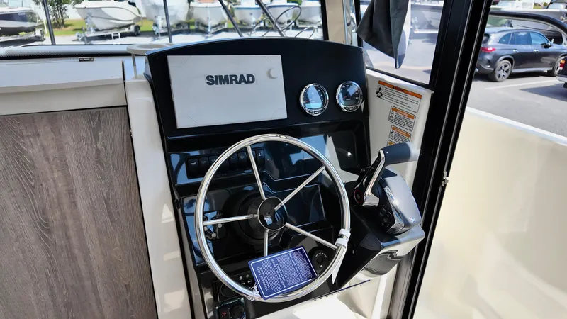 Slide: The Image of Pilothouse of 2025 Bayliner Trophy 23 with Simrad navigation system and steering wheel. - 28