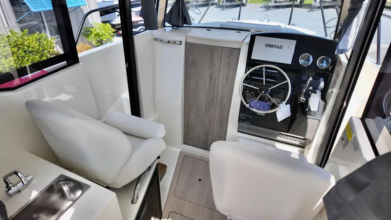 Slide: The Image of 2025 Bayliner Trophy 23 Pilothouse interior with steering wheel and seating. - 29