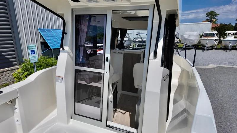 Slide: The Image of Bayliner Trophy 23 Pilothouse 2025, showcasing sleek design and spacious interior at a marina. - 30