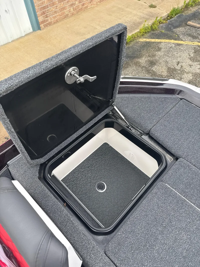 Slide: The Image of Open storage compartment on 2025 Vexus VXS20 boat, featuring a secure latch and carpeted surface. - 36