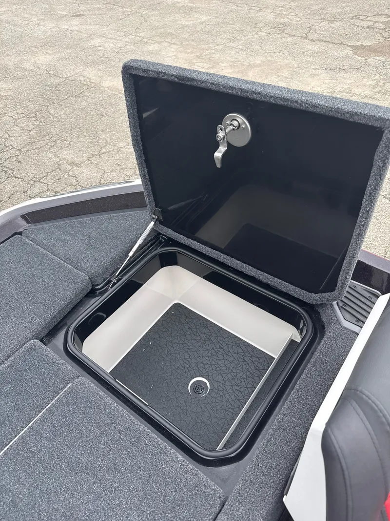 Slide: The Image of Open storage compartment on 2025 Vexus VXS20 boat, featuring a secure latch and carpeted surface. - 37