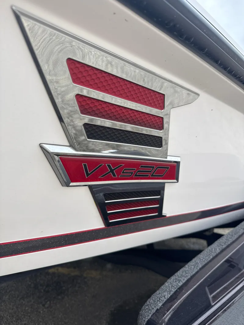 Slide: The Image of 2025 Vexus VXS20 emblem with red and silver design on a white surface. - 6