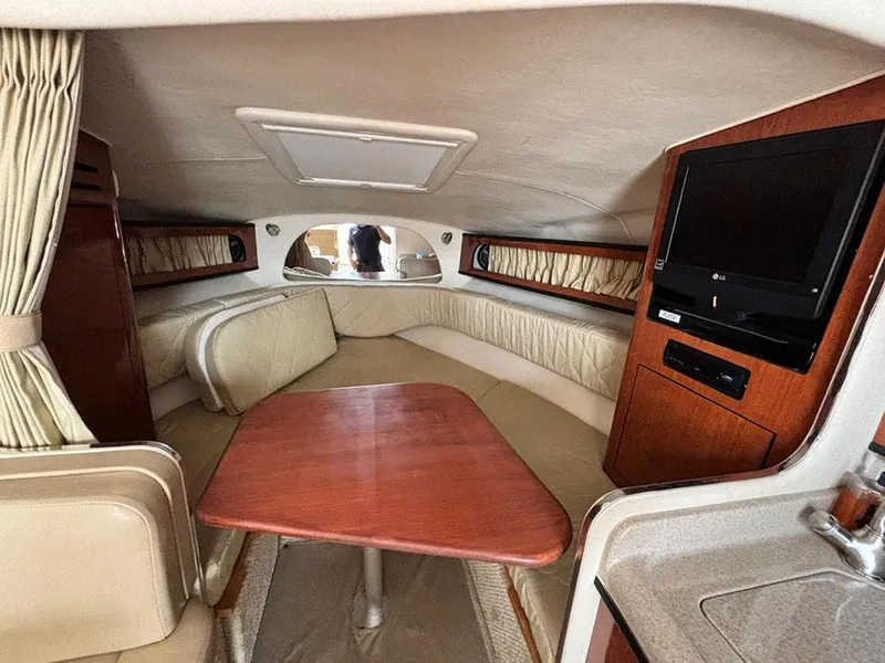 Slide: The Image of Interior of 2007 Sea Ray 280 Sundancer with seating, table, and TV. - 15