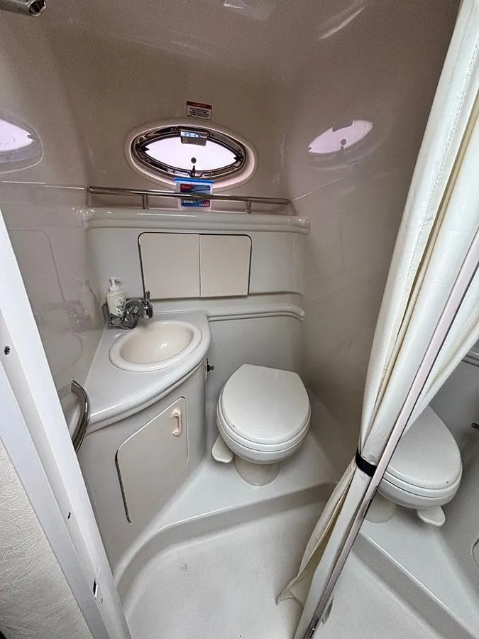 Slide: The Image of 2007 Sea Ray 280 Sundancer bathroom with sink, toilet, and porthole window. - 17