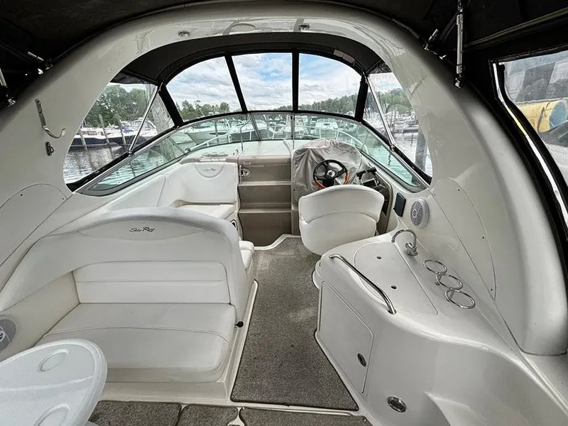 Slide: The Image of 2007 Sea Ray 280 Sundancer boat interior with white seating and helm, docked at marina. - 6