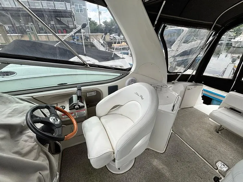 Slide: The Image of 2007 Sea Ray 280 Sundancer cockpit with white seating and steering wheel. - 9