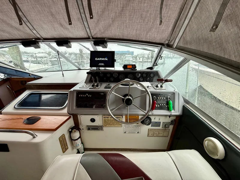 Slide: The Image of 1989 Sea Ray 340 Sundancer helm with Garmin navigation, steering wheel, and control panel. - 8