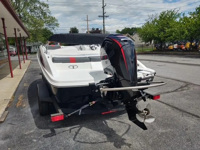 Slide: The Image of 2024 Tahoe T18 boat with outboard motor on a trailer, parked outdoors. - 4