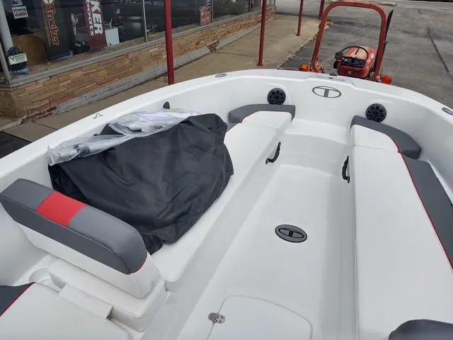 Slide: The Image of 2024 Tahoe T18 boat interior with white seating and red accents, parked outdoors. - 7