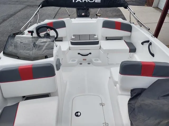 Slide: The Image of 2024 Tahoe T18 boat interior with red and gray seating, steering wheel, and console. - 8
