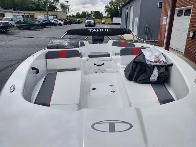 Slide: The Image of 2024 Tahoe T18 boat with spacious seating and sleek design, parked outdoors. - 9