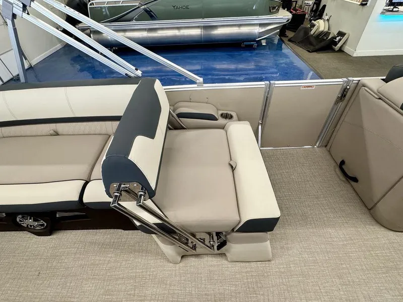 Slide: The Image of 2025 Tahoe Cascade 2385 QLS boat interior with beige and navy seating. - 11