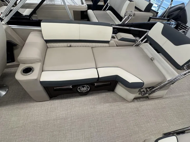 Slide: The Image of 2025 Tahoe Cascade 2385 QLS boat interior with beige and black seating, cup holder, and speaker. - 15
