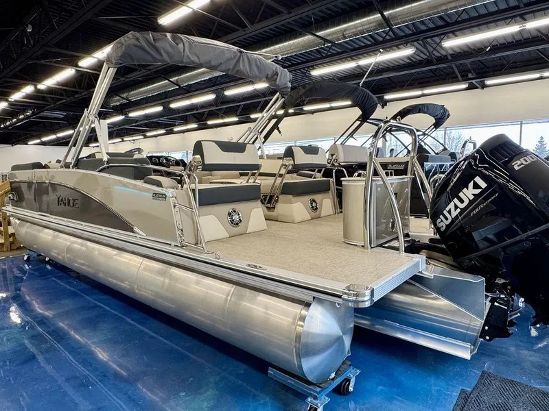 Slide: The Image of 2025 Tahoe Cascade 2385 QLS pontoon boat with Suzuki engine in showroom. - 2