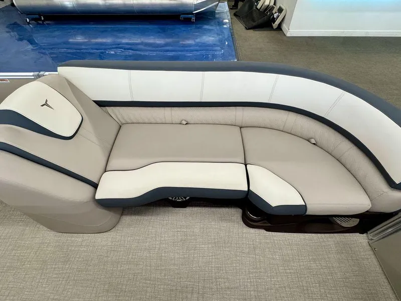 Slide: The Image of 2025 Tahoe Cascade 2385 QLS boat interior with luxurious beige and navy seating. - 9