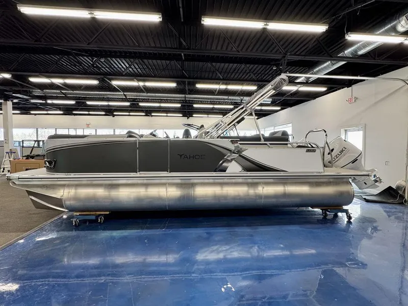 Slide: The Image of 2025 Tahoe LTZ 2385 QLS pontoon boat displayed indoors on blue floor. - 0