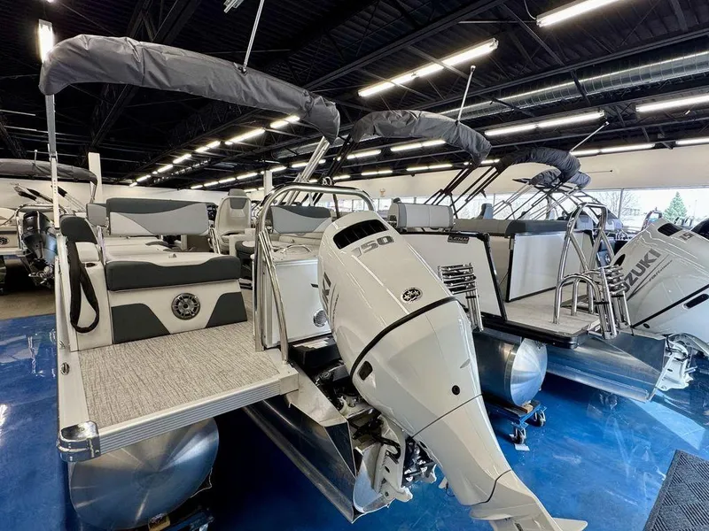 Slide: The Image of 2025 Tahoe LTZ 2385 QLS pontoon boat with powerful outboard motor in showroom. - 1