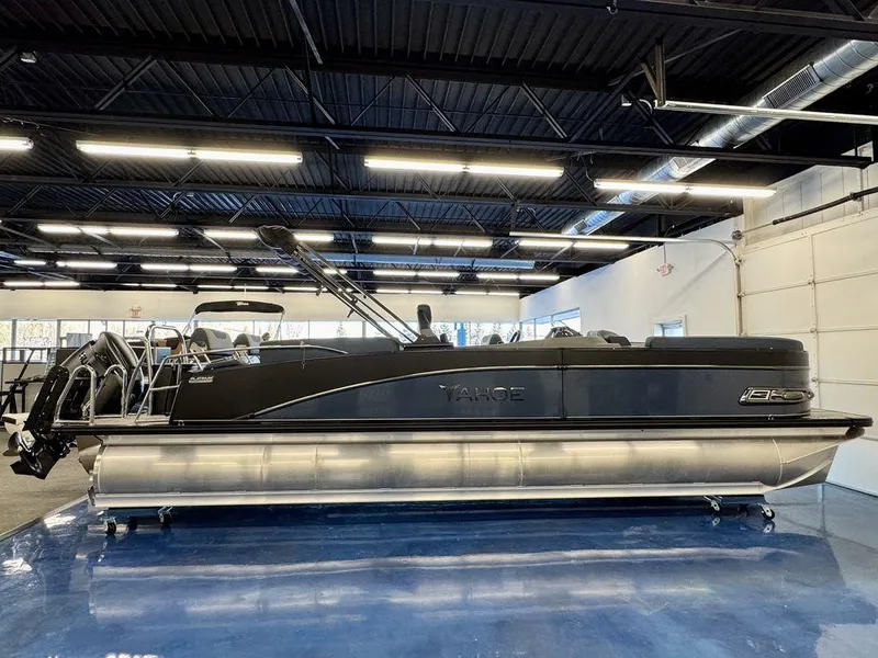 Slide: The Image of 2025 Tahoe Cascade 2585 QLS pontoon boat displayed indoors on a blue floor. - 0