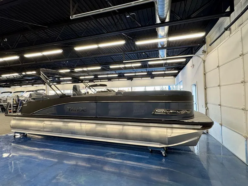Slide: The Image of 2025 Tahoe Cascade 2585 QLS pontoon boat displayed in a showroom. - 1