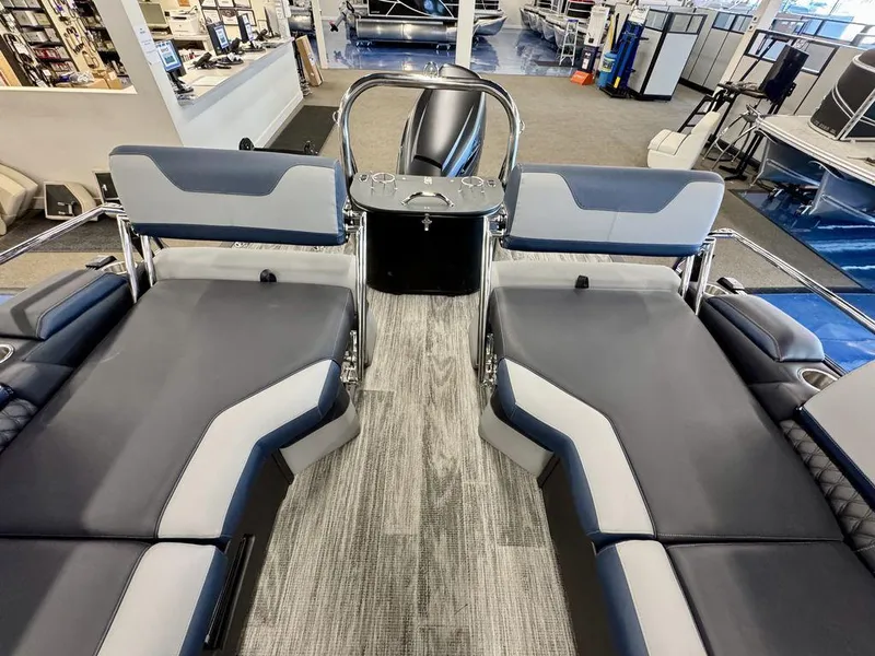 Slide: The Image of 2025 Tahoe Cascade 2585 QLS boat interior with gray seating and modern design in showroom. - 14