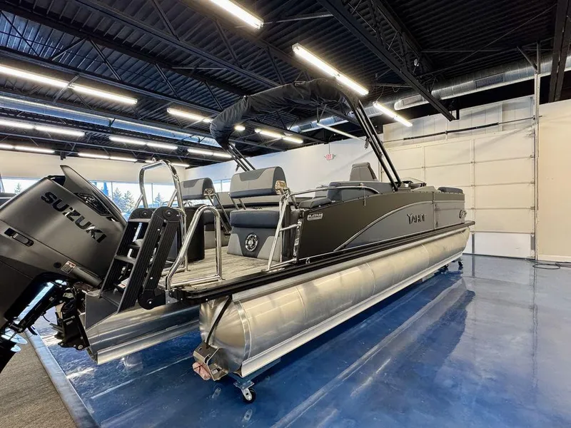 Slide: The Image of 2025 Tahoe Cascade 2585 QLS pontoon boat with Suzuki engine in showroom. - 2