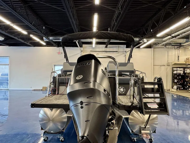 Slide: The Image of 2025 Tahoe Cascade 2585 QLS pontoon boat in showroom, rear view with powerful engine. - 3