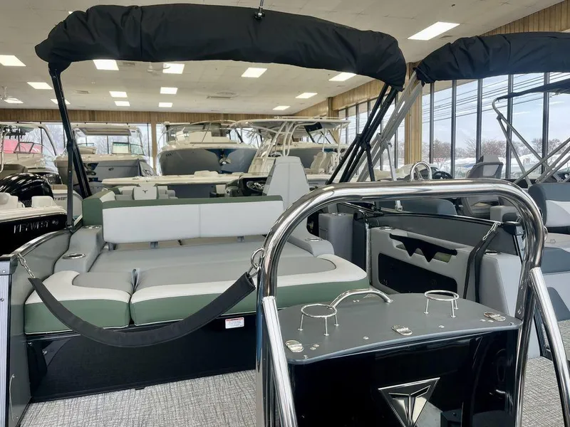 Slide: The Image of 2025 Tahoe Cascade 2385 VRB pontoon boat interior in showroom, featuring sleek seating and modern design. - 6