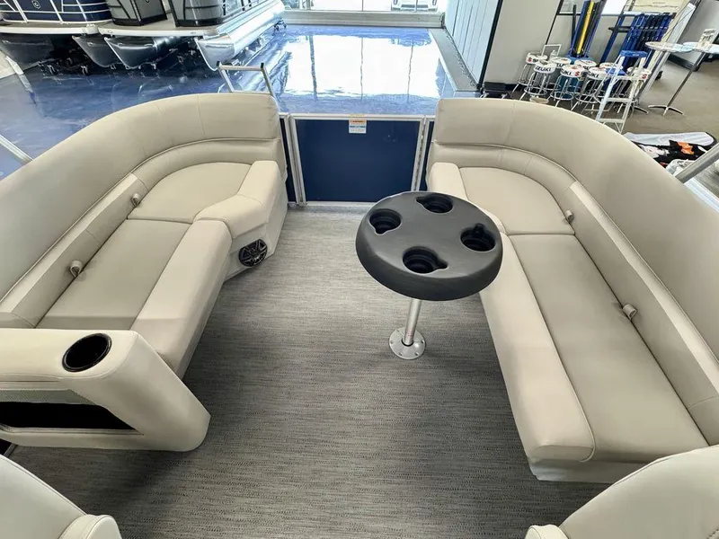 Slide: The Image of 2025 Godfrey EX 2286 SBX pontoon boat interior with beige seating and cupholder table. - 10