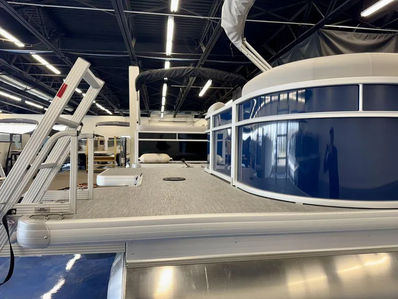 Slide: The Image of 2025 Godfrey EX 2286 SBX pontoon boat in showroom, featuring sleek design and modern amenities. - 3