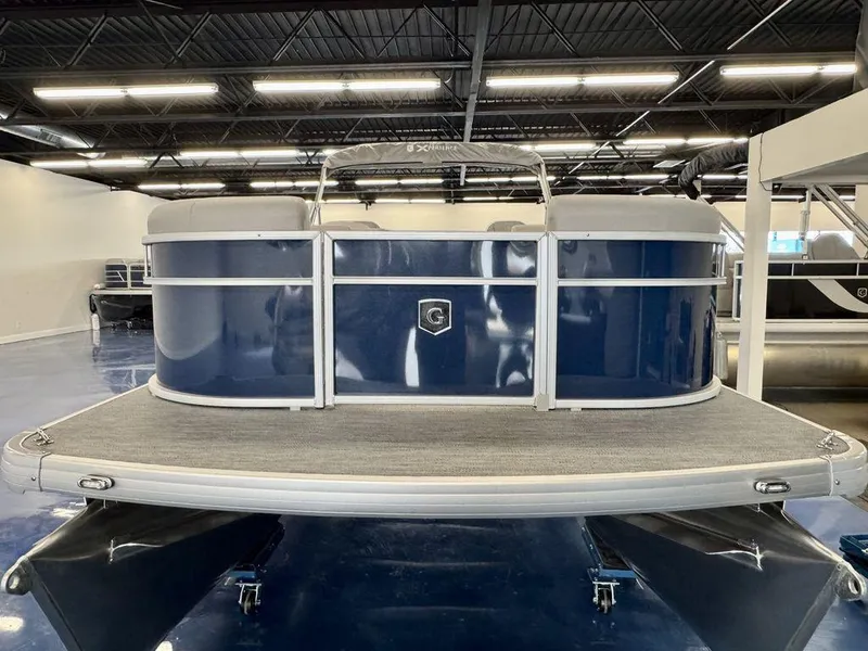 Slide: The Image of 2025 Godfrey EX 2286 SBX pontoon boat in showroom, featuring sleek blue design. - 4