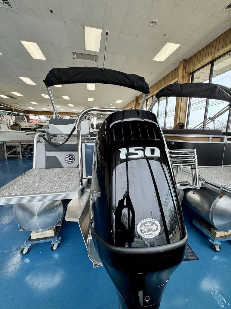 Slide: The Image of 2025 Tahoe LTZ 2385 QLS pontoon boat with 150 HP engine in showroom. - 2
