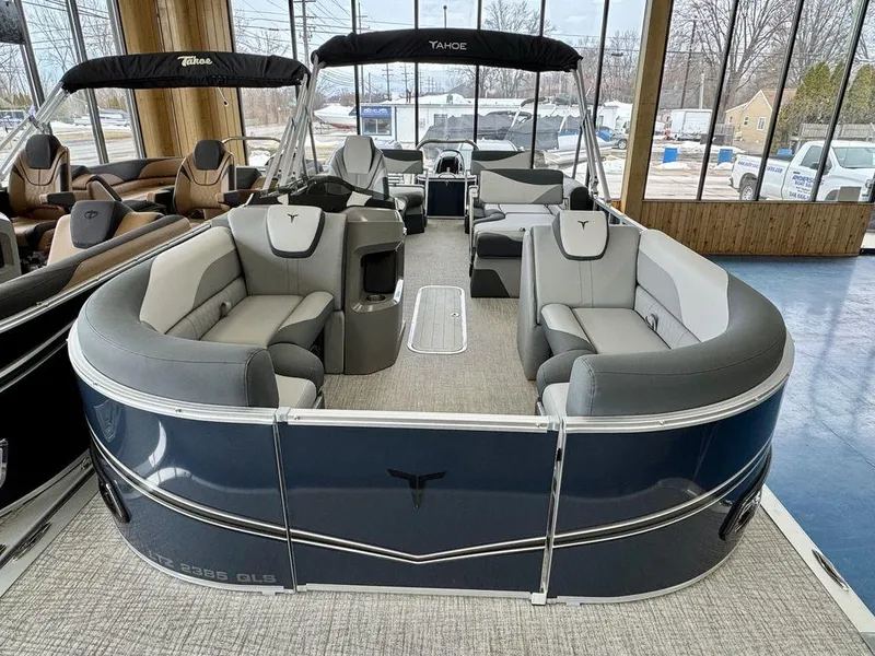 Slide: The Image of 2025 Tahoe LTZ 2385 QLS pontoon boat with luxurious seating in showroom. - 6