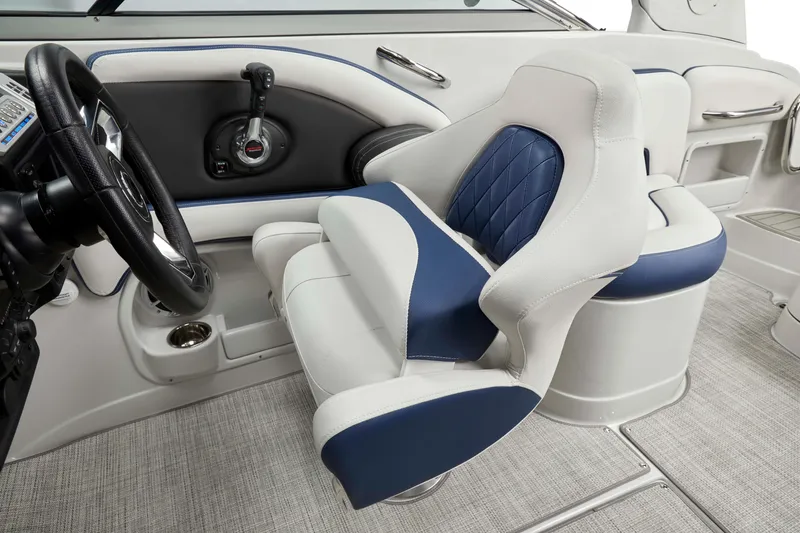 Slide: The Image of 2024 Crownline 250 XSS boat interior with blue and white seating and control panel. - 6