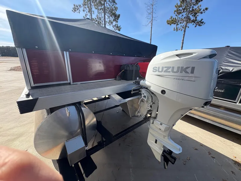 Slide: The Image of Custom Maui 16 Fisherman 2025 boat with Suzuki outboard motor, parked outdoors. - 6