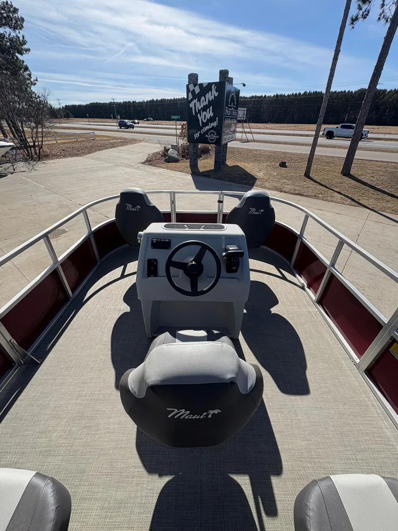 Slide: The Image of Custom Maui 16 Fisherman boat, 2025 model, with steering console and seating, parked outdoors. - 8