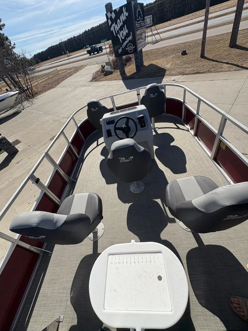 Slide: The Image of 2025 Custom Maui 16 Fisherman boat with seating and steering console, parked outdoors. - 9