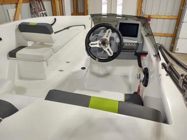 Slide: The Image of 2023 Tahoe T16 boat interior with steering wheel, seating, and control panel in a garage setting. - 3