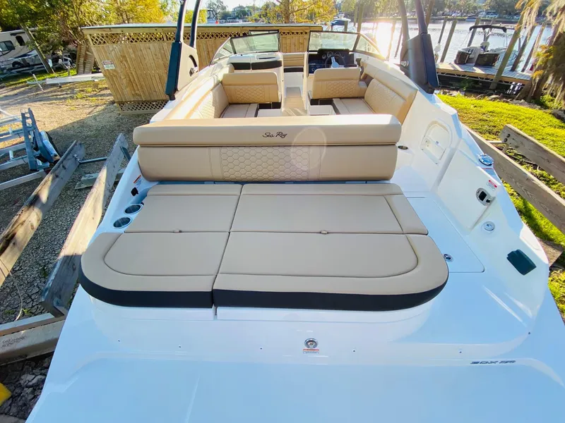 Slide: The Image of 2022 Sea Ray 270 SDX boat with spacious seating and sun deck, docked outdoors. - 11