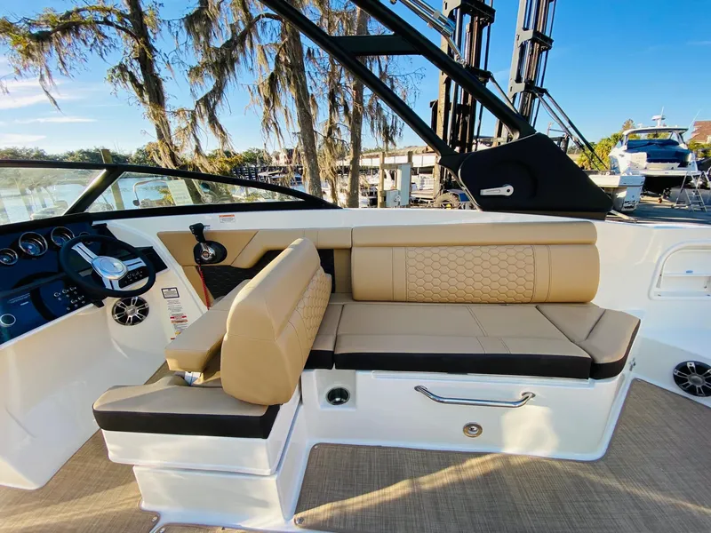 Slide: The Image of 2022 Sea Ray 270 SDX boat interior with beige seating and modern dashboard. - 14