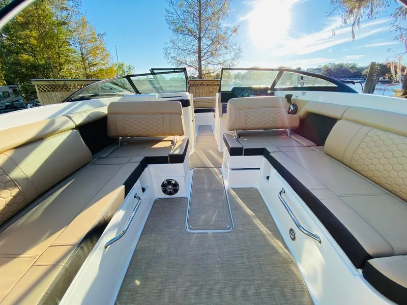 Slide: The Image of 2022 Sea Ray 270 SDX boat interior with beige seating and sunny outdoor view. - 19
