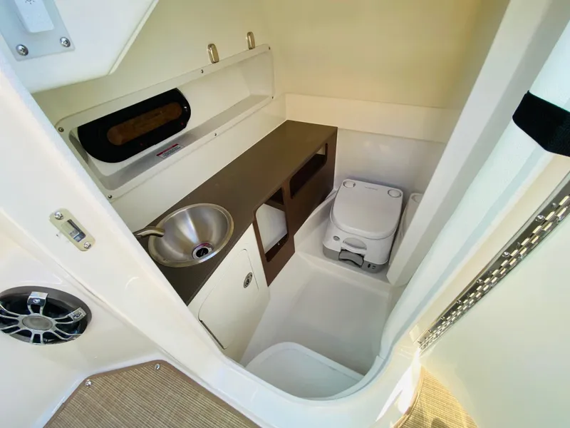 Slide: The Image of 2022 Sea Ray 270 SDX boat interior with sink, toilet, and storage. - 20