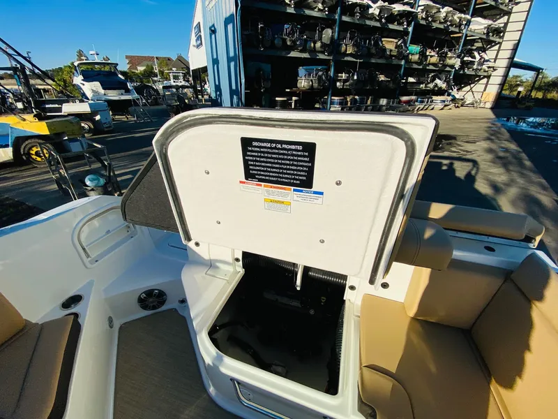 Slide: The Image of 2022 Sea Ray 270 SDX boat interior with open storage compartment at marina. - 28